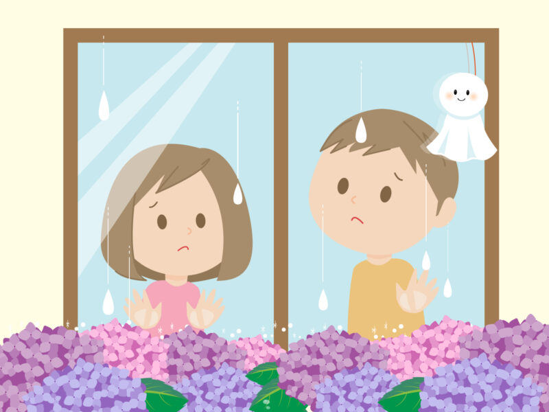 雨の日の窓から外を眺める子ども
